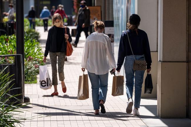 © Bloomberg. Shoppers wearing protective masks carry bags in the Broadway Plaza Shopping Center in Walnut Creek, California, U.S., on Wednesday, April 14, 2021. U.S. retail sales probably swelled in March thanks to faster hiring, the distribution of federal stimulus checks, a steady pace of Covid-19 vaccinations and fewer restrictions on stores across the country. Photographer: David Paul Morris/Bloomberg