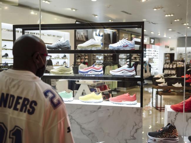 © Bloomberg. A shopper browses sneakers displayed in the window of a store in San Francisco. Photographer: Michael Short/Bloomberg