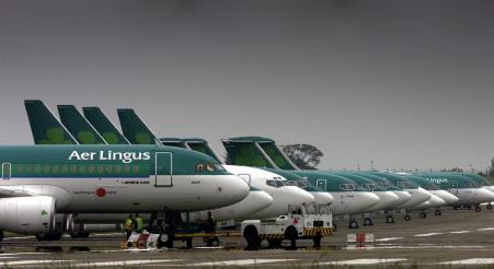 © Reuters/Paul McErlane. Aer Lingus Airbus A320 are parked away from the passenger terminals at Dublin Airport in Ireland June 2, 2002.