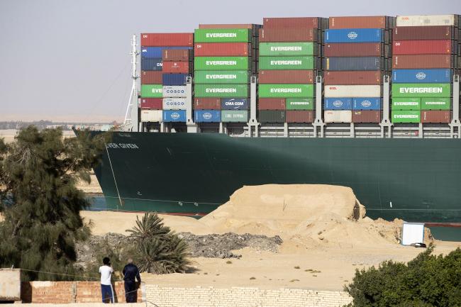 © Bloomberg. People watch as the 'Ever Given' is refloated, unblocking the Suez Canal on March 29.