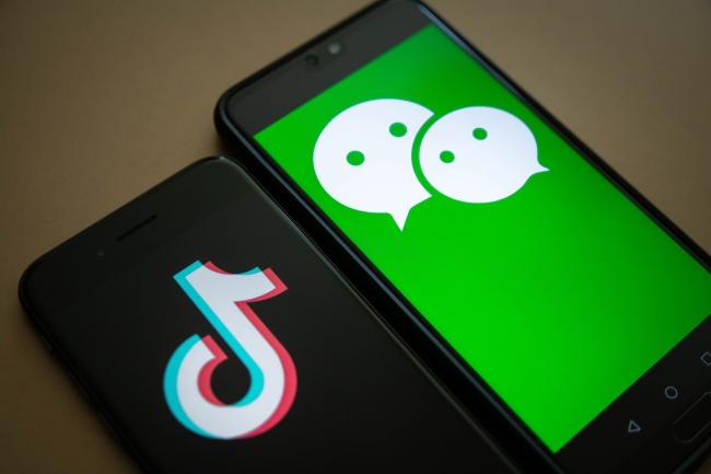 © Bloomberg. The logo for Tencent Holdings Ltd.'s WeChat app, right, and the logo for ByteDance Ltd.'s TikTok app are arranged for a photograph on smartphones in Hong Kong, China, on Friday, Aug. 7, 2020. President Donald Trump signed a pair of executive orders prohibiting U.S. residents from doing business with the Chinese-owned TikTok and WeChat apps beginning 45 days from now, citing the national security risk of leaving Americans' personal data exposed.