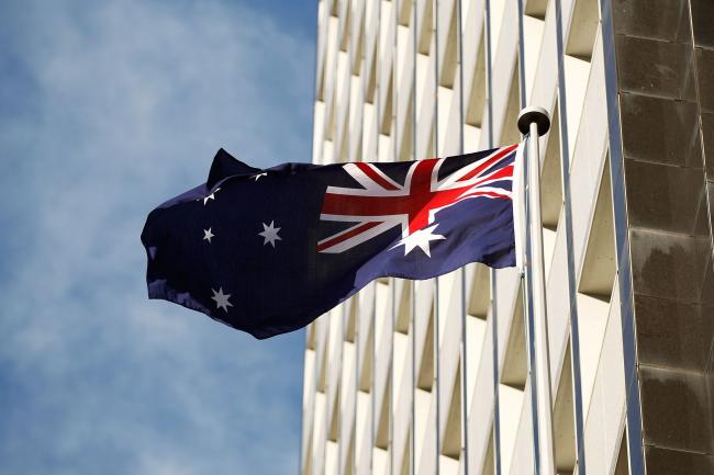 © Bloomberg. The Australian flag flies outside the Reserve Bank of Australia (RBA) headquarters in Sydney, Australia, on Monday, July 4, 2016. Australia's failure to make a decisive political choice coupled with ongoing Brexit fallout point to the central bank waiting a month to assess the implications before resuming interest-rate cuts. Photographer: Brendon Thorne/Bloomberg