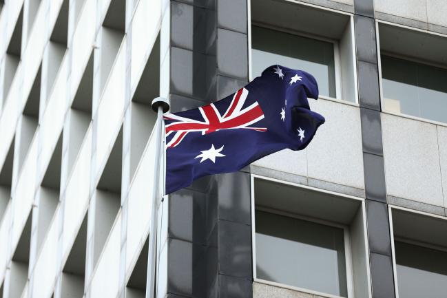 © Bloomberg. The Australian flag flies outside the Reserve Bank of Australia (RBA) headquarters in Sydney, Australia, on Monday, Dec. 4, 2017. Australia's central bank is on track for its longest stretch of unchanged interest rates as it bets a tightening job market will begin to put upward pressure on wages -- at some stage. Photographer: Brendon Thorne/Bloomberg