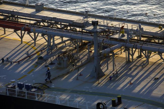 © Bloomberg. A crew member walks on the deck of an oil tanker anchored in the Pacific Ocean in this aerial photograph taken above Long Beach, California, U.S., on Friday, May 1, 2020. The volume of oil on vessels located just offshore the state peaked at 26 million barrels over the weekend, about a quarter of the world's daily consumption, before dropping to 22 million barrels on Monday, according to Paris-based Kpler SAS, which tracks tanker traffic. Photographer: Patrick T. Fallon/Bloomberg