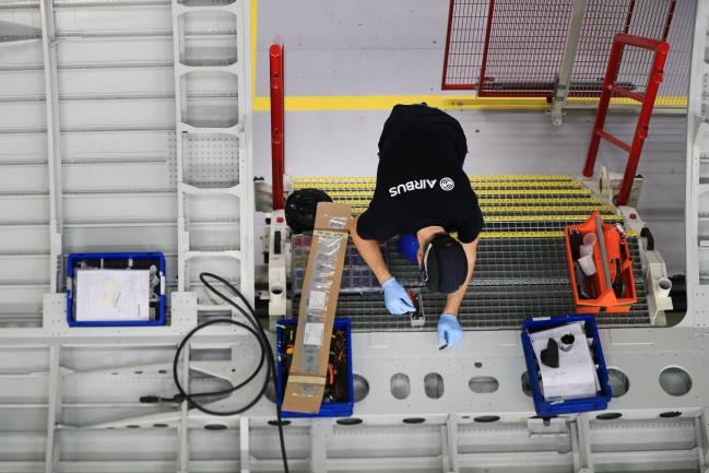 © Bloomberg. An employee works on a section of fuselage inside the new Airbus SE A320 passenger aircraft family assembly line hangar in Hamburg, Germany, on Tuesday, Oct. 1, 2019. An escalating battle over aircraft subsidies between the U.S. and the European Union threatens to damage both sides, said Airbus Chief Executive Officer Guillaume Faury.
