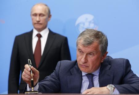 © Reuters. Russia's President Vladimir Putin (back) and Rosneft CEO Igor Sechin attend a signing ceremony in May 2014. Sechin this week denied that the Russian oil company played a part in the ruble's collapse.