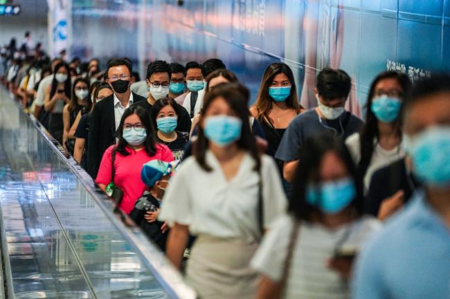 © Bloomberg. Commuters wearing protective masks walk through Hong Kong Station, operated by MTR Corp., in Hong Kong, China, on Wednesday, July 15, 2020. Hong Kong implemented its strictest suite of social distancing measures yet as the Asian financial hub looks set to be the first in the region where a new outbreak surpasses previous waves in severity. Photographer: Lam Yik/Bloomberg
