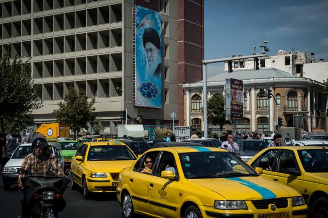© Bloomberg. Yellow taxi cabs sit in a traffic jam overlooked by a poster depicting Iranian Supreme Leader Ayatollah Ali Khamenei on a city highway in Tehran, Iran, on Tuesday, Sept. 17. 2019. Iranian Foreign Minister Mohammad Javad Zarif refused to rule out military conflict in the Middle East after the U.S. sent more troops and weapons to Saudi Arabia in response to an attack on oil fields the U.S. has blamed on the Islamic Republic.