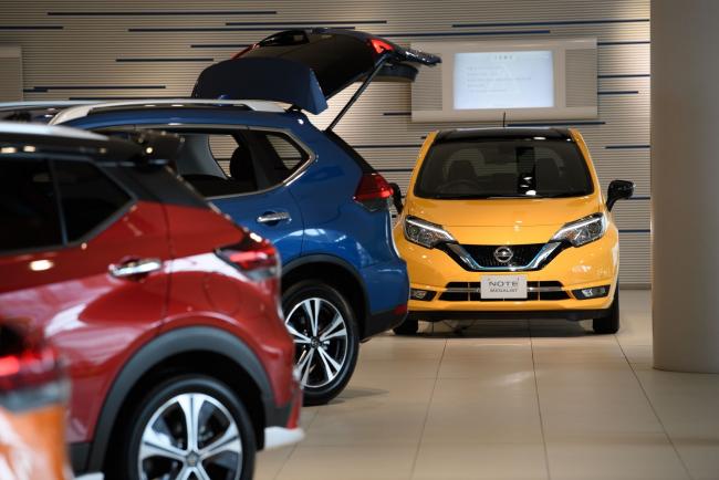 © Bloomberg. Nissan Motor Co. vehicles, including Note e-Power, right, stand on display in a showroom at the company's headquarters in Yokohama, Japan, on Tuesday, July 28, 2020. Nissan is struggling to restore profitability and sales after the November 2018 arrest of its former Chairman Carlos Ghosn and because a lack of new models left it ill-prepared to face a downturn in global vehicle demand amid the coronavirus pandemic. Photographer: Akio Kon/Bloomberg