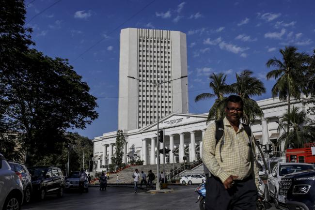 © Bloomberg. A pedestrian walks past the {{0|Reserve Bank of India}} (RBI) in Mumbai, India, on Monday, March. 9, 2020. A top Indian official said there's no need for the government to take immediate steps to support the economy following a crash in oil prices that has sent financial markets into a tailspin. Photographer: Dhiraj Singh/Bloomberg