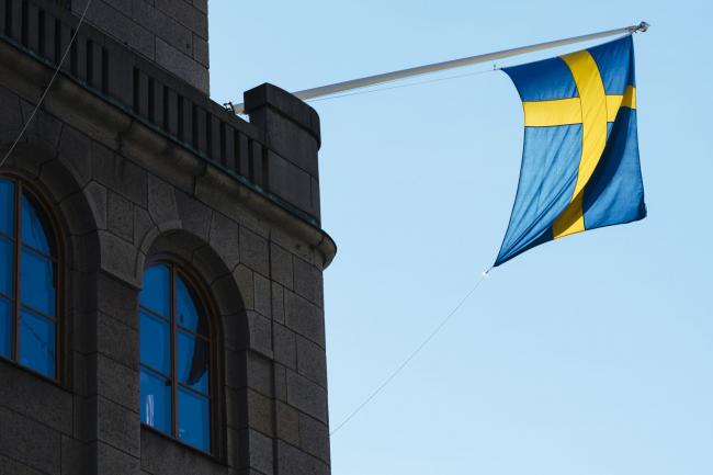 © Bloomberg. A national flag of Sweden hangs from a commercial building in Stockholm, Sweden, on Wednesday, June 28, 2017. Just as Sweden’s biggest mortgage banks start raising interest rates, the country’s state-backed home-loan provider says it’s cutting customers’ borrowing costs in a move that threatens to hurt industry profits after years of negative rates. Photographer: Mikael Sjoberg/Bloomberg