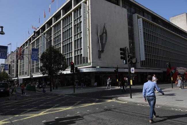 © Bloomberg. A pedestrian crosses Oxford Street outside the John Lewis Partnership Plc department store in London.