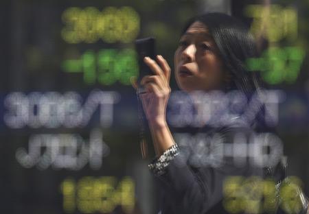 © Reuters. A woman looking at a stock quotation board in Tokyo on Sept. 29, 2015. Japan stocks fell today as a global rally faltered.