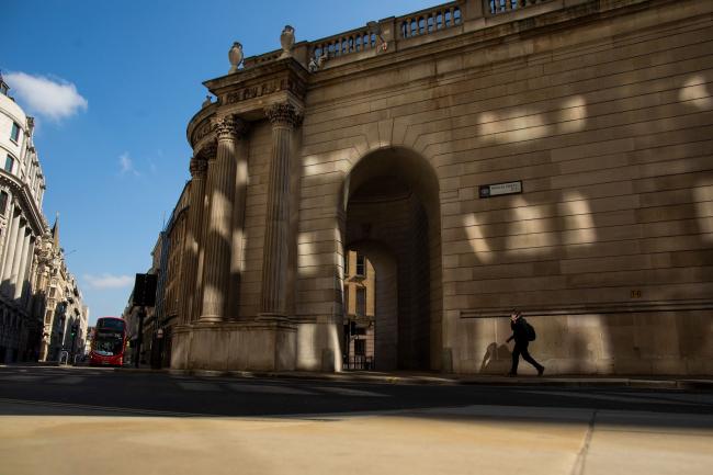 © Bloomberg. A pedestrian passes the Bank of England (BOE) in the City of London, U.K., on Wednesday, May 6, 2020. Bank of England policy makers will meet this week knowing that they'll probably have to do more to combat the U.K.’s economic slump, if not now then soon. Photographer: Simon Dawson/Bloomberg