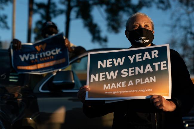 © Bloomberg. An attendee wears a protective mask while holding a 