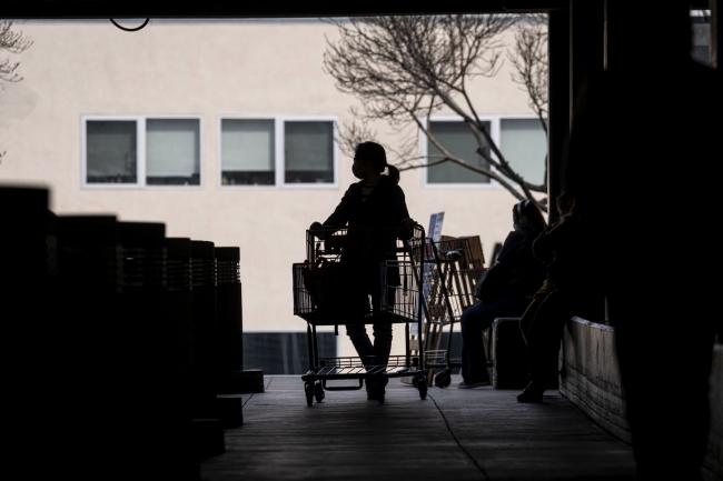 © Bloomberg. A customer wearing a protective mask exits a Costco store in San Francisco.
