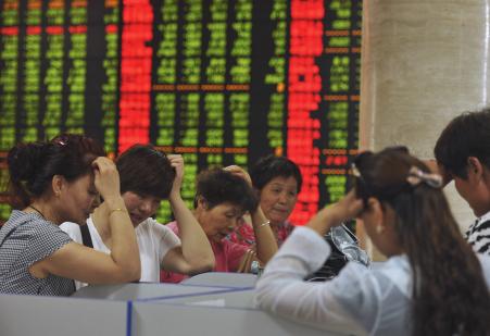 © Reuters. Investors react as they look at computer screens showing stock information at a brokerage house in Fuyang, Anhui province, China, on July 28, 2015.