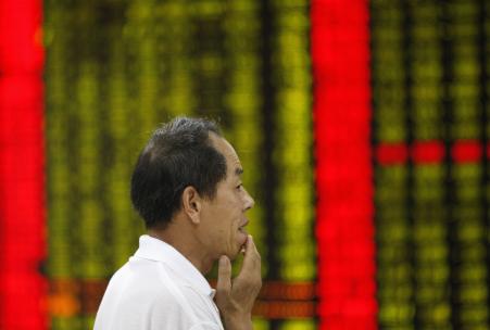 © Reuters. An investor looks at an electronic board showing stock information at a brokerage house in Huaibei, China, July 27, 2015.
