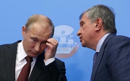 © Reuters. Russia's President Vladimir Putin (left) and Igor Sechin, CEO of Russia's state-owned oil giant Rosneft, attend a 2014 signing ceremony. Rosneft sources told Reuters Friday that Western sanctions will force the company to delay its Arctic drilling agenda in 2015.