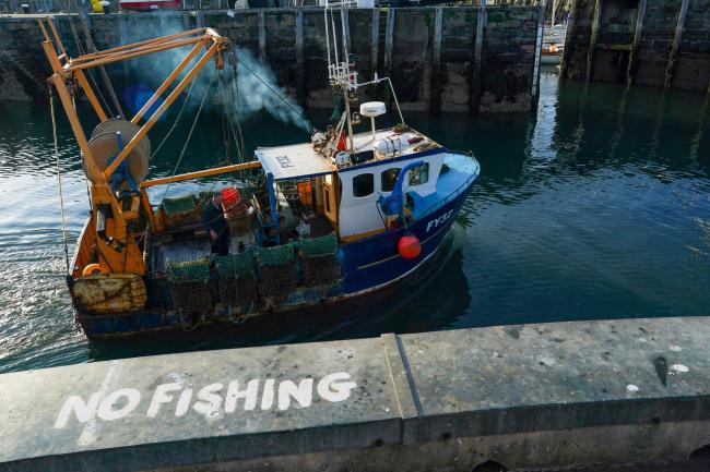 © Bloomberg. A 'No Fishing' sign sits on the quayside as a fishing boat heads out to sea from the harbour in Scarborough, U.K., on Tuesday, June 2, 2020. The threat of a no-deal Brexit is back -- and with it the risk that the U.K. economy's shaky recovery from the coronavirus pandemic will be hobbled.