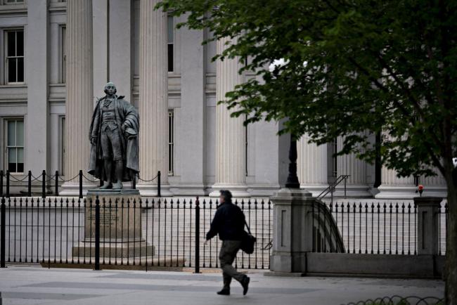 © Bloomberg. A pedestrian walks near the U.S. Treasury building in Washington, D.C., U.S., on Wednesday, May 20, 2020. Treasury Secretary Steven Mnuchin said he plans to use all of the $500 billion that Congress provided to help the economy through direct lending from his agency and by backstopping Federal Reserve lending programs.