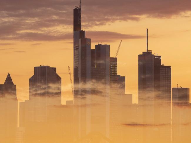 © Bloomberg. EDITORS NOTE: Multiple exposures were combined in camera to produce this image. An image of clouds at sunset overlays the skyscraper skyline of the financial district in Frankfurt, Germany, on Monday, July 1, 2019. Following the collapse of merger talks between Deutsche Bank and Commerzbank, German Finance Minister Olaf Scholz changed his message from supporting a national champion to backing a cross-border merger.