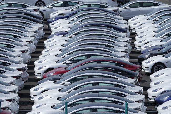 © Bloomberg. Tesla Inc. vehicles in a parking lot after arriving at a port in Yokohama, Japan, on Monday, May 10, 2021. While the situation is likely to grow murkier in the summer, so far Toyota has emerged largely unscathed from the chip shortage miring its competitors. Photographer: Toru Hanai/Bloomberg
