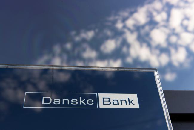 © Bloomberg. A logo sits on display in the window of a Danske Bank A/S bank branch in Copenhagen, Denmark, on Wednesday, Sept. 19, 2018. Danske Bank A/S Chief Executive Officer Thomas Borgen will step down amid allegations his bank was at the center of a major European money laundering scandal with as much as $234 billion flowing through a tiny unit in Estonia.