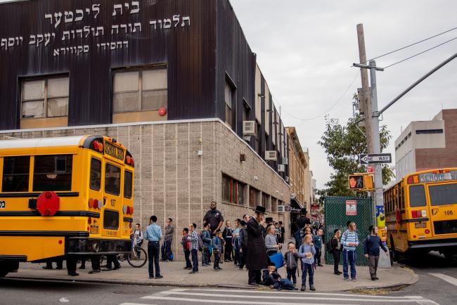 © Bloomberg. Students stand outside a school in the Borough Park neighborhood in the Brooklyn borough of New York, U.S., on Thursday, Sept. 24, 2020. New York City Mayor Bill de Blasio said a recent uptick of coronavirus cases in south Brooklyn and Queens neighborhoods requires 