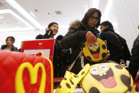 © Reuters/Andrew Winning. A shopper reaches for a handbag as she hunts for bargains at Selfridges department store on the first day of their sales, in central London, Dec. 26, 2014.