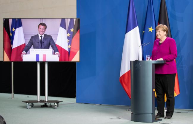 © Bloomberg. BERLIN, GERMANY - MAY 18: German Chancellor Angela Merkel and French President Emmanuel Macron, seen present live via video, speak to the media at the Chancellery during the coronavirus crisis on May 18, 2020 in Berlin, Germany. The two leaders announced they intend to launch a joint European Union recovery initiative to the tune of EUR 500 billion. (Photo by Andreas Gora - Pool/Getty Images)