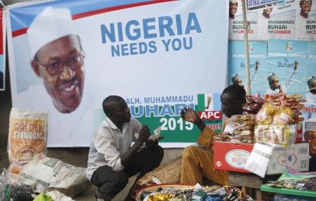 © Reuters/Akintunde Akinleye. Vendors sell their wares near an election poster of former Nigerian military ruler Muhammadu Buhari before the start of All Progressives Congress (APC) party convention in Lagos December 10, 2014. Nigeria's main opposition coalition began a convention on Wednesday to select a candidate to take on President Goodluck Jonathan in February, in what will be the most closely fought election since the end of military rule in 1999.