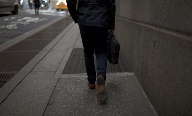 © Bloomberg. A pedestrian walks along a street near the New York Stock Exchange. Photographer: Jordan Sirek/Bloomberg