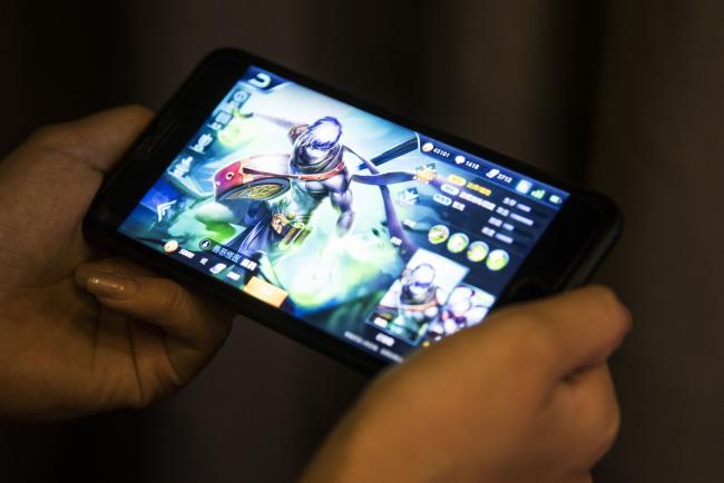 © Bloomberg. An avatar is displayed in an arranged photograph of the Honour of Kings mobile game, developed by Tencent Holdings Ltd., in Hong Kong, China, on Friday, Aug. 18, 2017. The mobile smash, where professional doppelgangers get paid to help newbies climb both social and gaming ladders, is expected to generate as much as $3 billion in revenue this year.