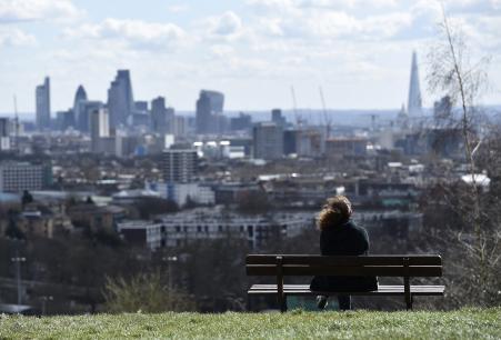 © Reuters/Toby Melville. A woman looks towards the City of London financial district from Parliament Hill in north London, March 31, 2015.
