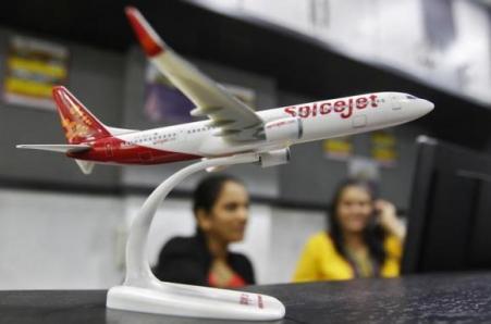 © Reuters/Amit Dave. Employees work inside a travel agency office besides a model of a SpiceJet aircraft in Ahmedabad on Feb. 14, 2014.