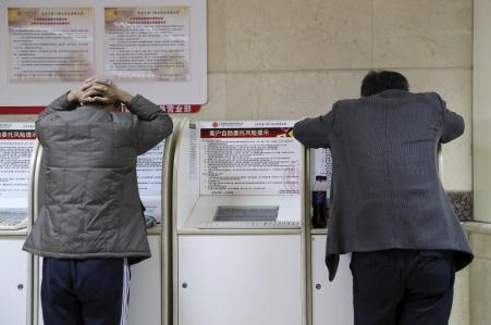 © Reuters/Li Sanxian. China's business sentiment sank to a record low according to Markit Survey. Pictured: Investors look at computer screens showing stock information at a brokerage house in Beijing, China, Oct. 30, 2015.